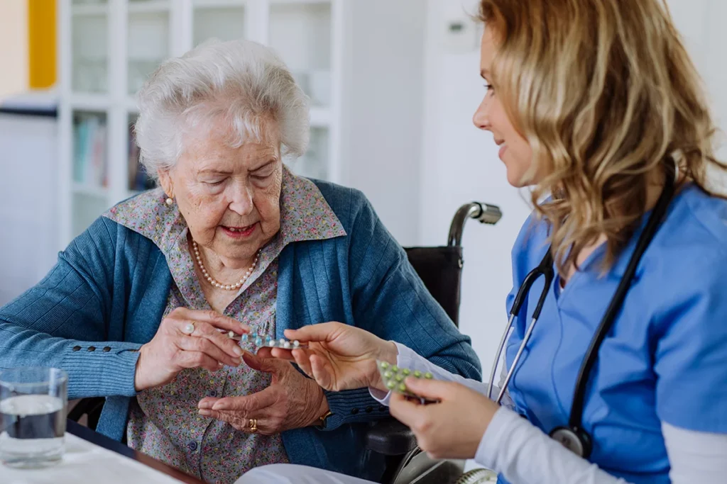 caring nurse provides medication to senior woman
