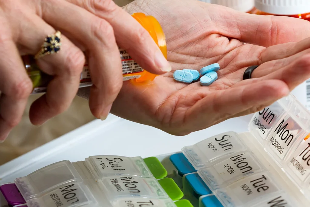 close up of a hand handling prescriptions pills