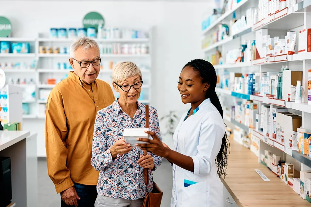 senior couple consulting with pharmacist in pharma