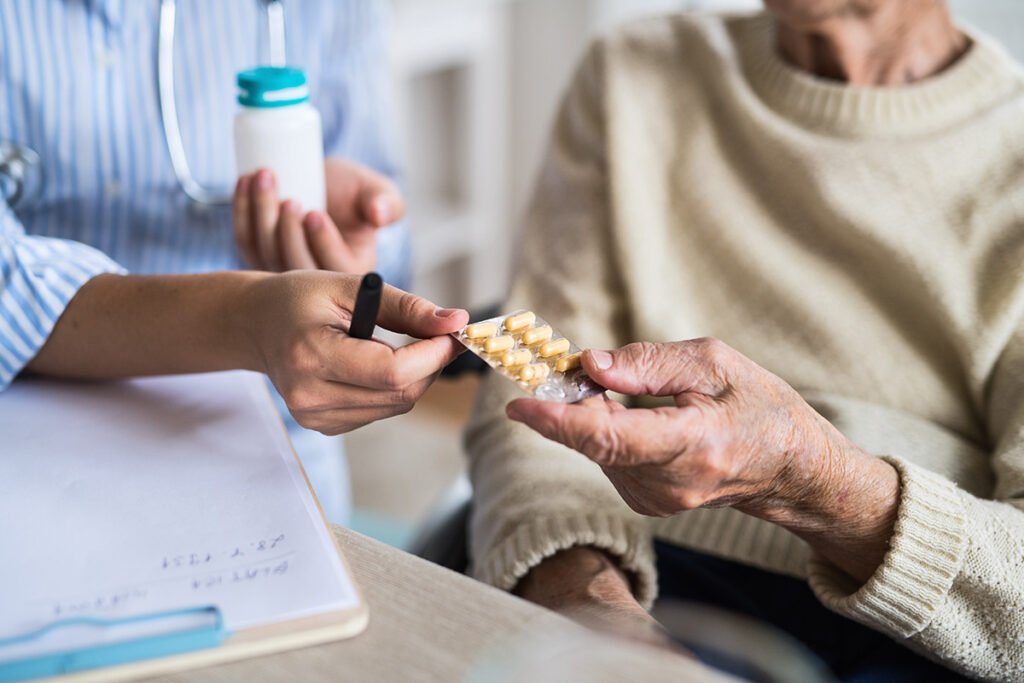 senior woman receiving medication from healthcare